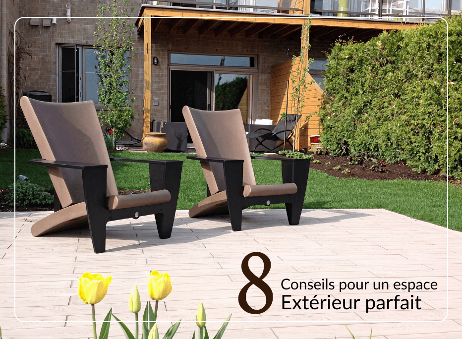 Deux chaises longues extérieures au design contemporain, avec structure noire et coussins taupe, disposées sur une terrasse en pierre face à un aménagement paysager verdoyant et une façade architecturale moderne.