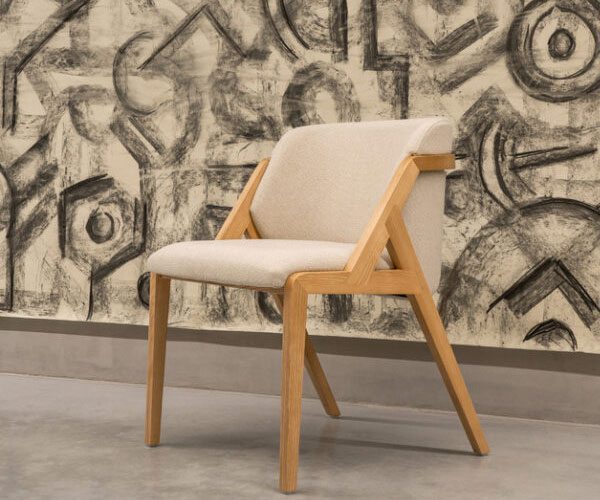 A chair sitting in front of a wall with a painting on it