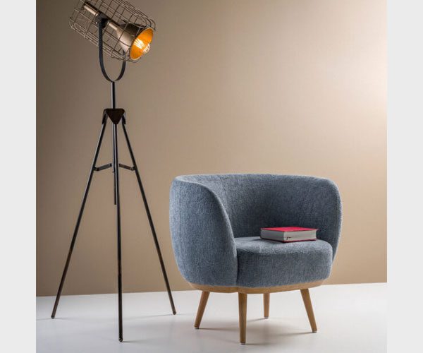 A chair with a book on it next to a lamp