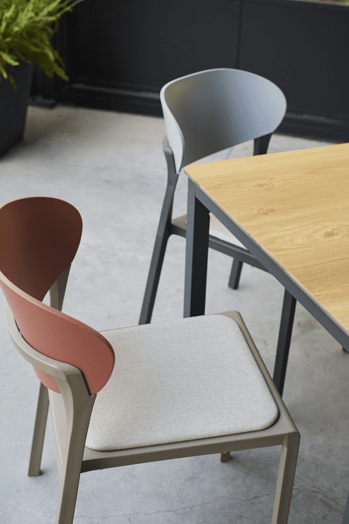 Close-up of Bake Collection dining chairs showcasing upholstered seats, contemporary color finishes, and refined hospitality-focused design details.