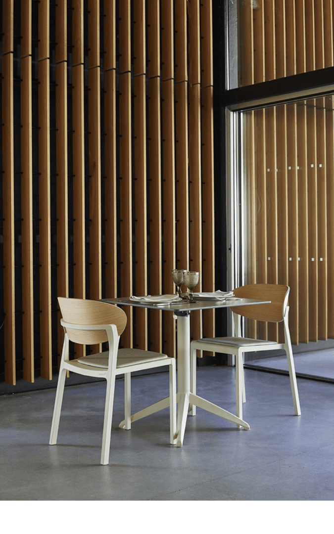 Modern commercial dining chair with upholstered seat and wood veneer backrest in a contemporary restaurant setting.