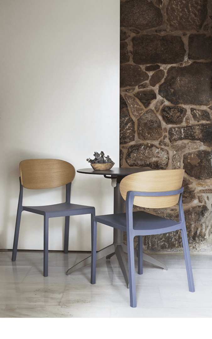 Contemporary commercial dining chairs featuring wood veneer backrests and durable molded seats in a modern hospitality interior.