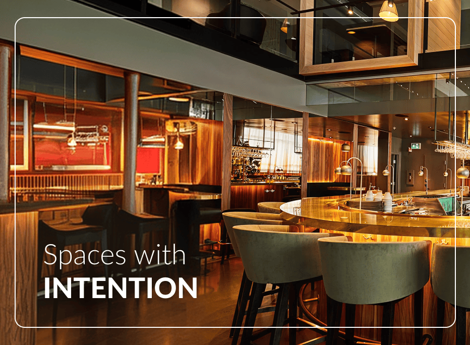 Premium hotel lounge bar featuring curved green velvet upholstered commercial bar stools surrounding a backlit gold counter with warm wood paneling and double-height architectural interior creating an intentional hospitality atmosphere.