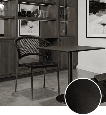 KECA metal chair in a bold black (Black Noir) powder-coat finish in a dining setting, showing a professional, high-contrast option for commercial interiors.