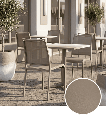 KECA metal chair in a neutral Warm Gray powder-coat finish in a layered interior, showing a versatile foundation tone for commercial seating.
