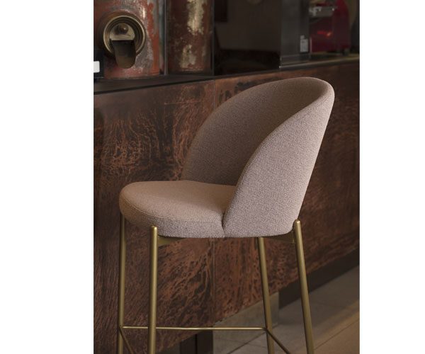 A bar stool with a beige upholstered seat