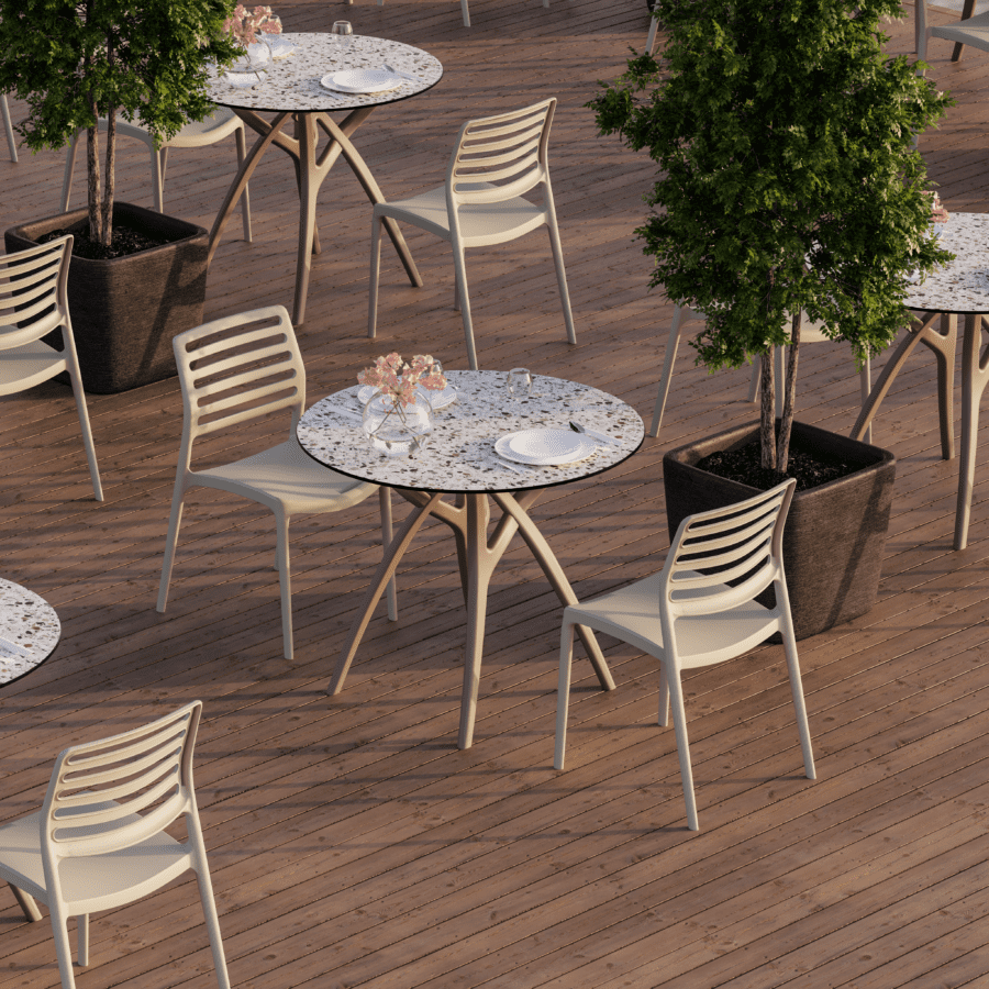 Senior care outdoor dining tables and chairs arranged on a landscaped terrace, featuring durable commercial-grade materials designed for senior living, healthcare, and hospitality outdoor environments.
